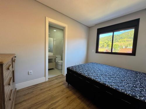 a small bedroom with a bed and a window at Polaris Residence Apto 2 Suítes para até 8 pessoas na Praia de Palmas in Governador Celso Ramos