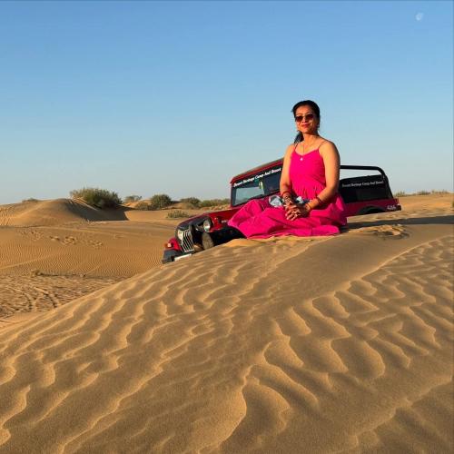 a woman sitting on the back of a truck in the desert at Hotel Robin Jaisalmer Near fort view in Jaisalmer