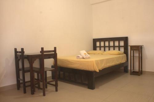 a bedroom with a bed and a table and chairs at Bungalows Rupay Wasi in Los Órganos