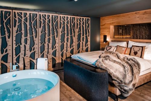 a bathroom with a bed and a bath tub at Schlosshotel Kitzbühel in Kitzbühel