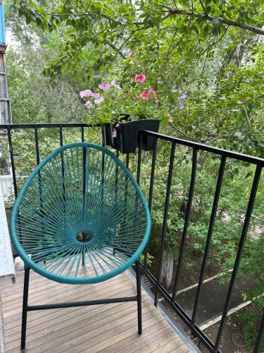 a blue bench sitting on a deck next to a fence at Уютная и стильная квартира в центре города Караганда in Karagandy