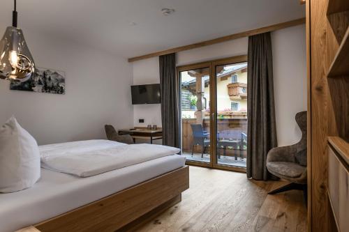 a hotel room with a bed and a balcony at Hotel Hubertushof in Grossarl