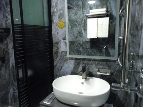 a bathroom with a white sink and a mirror at Urban Luxe in Almaty