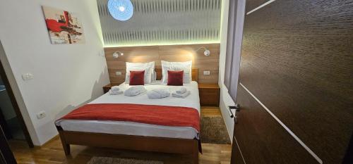 a small bedroom with a bed with a red blanket at AURA Residence in Rovinj