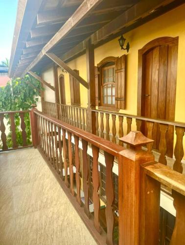 a balcony of a house with a wooden railing at Viva Brasil Pousada in Paraty