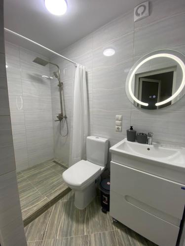 a white bathroom with a toilet and a sink at Yaremchuk lodge in Tyudov