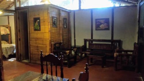 a living room with chairs and a room with a table at Guacamayo Rooms & Bungalows in Máncora