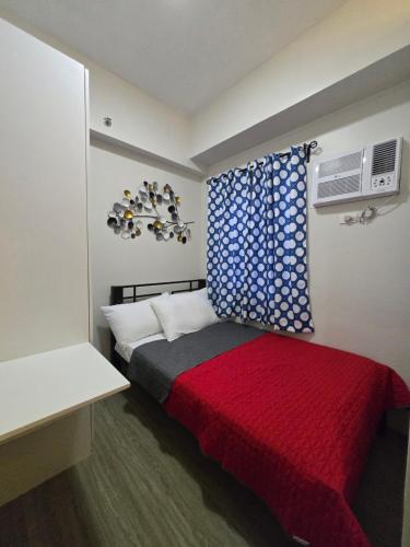 a bedroom with a bed with a red blanket at 2 Bedroom Suite in SM Marilao - Cheer Residence in Marilao