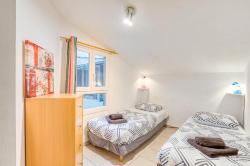 une chambre avec deux lits et une commode et une fenêtre dans l'établissement Appartement La Lumineuse, à Béziers