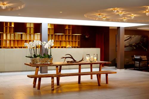 a table with flowers on it in a lobby at Waldhotel Stuttgart in Stuttgart
