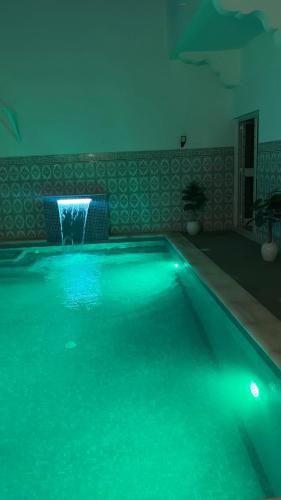 a swimming pool with a water fountain in a room at MAHDIA REJICHE MAISON AVEC PISCINE privee in Rejiche