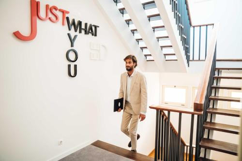 a man in a suit walking down a staircase at Stay Hotel Faro Centro in Faro
