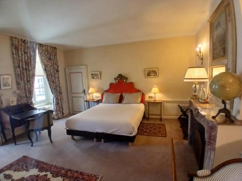 une chambre avec un grand lit et un bureau dans l'établissement La Résidence des Indes, à La Rochelle