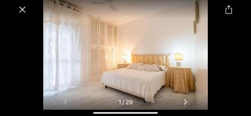a bedroom with a white bed and a window at Residence La Pineta a 500 mt dal mare Versilia in Le Focette