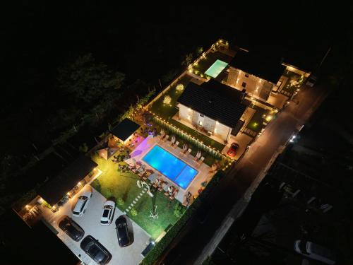 an aerial view of a house with a pool at night at Villa Guesthouse Albion in Lezhë