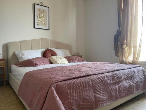 a bedroom with a large bed with a pink blanket at Maison De La Mer in Isthmia