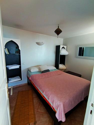 a bedroom with a bed with a red bedspread at Mirleft Horizon Suites in Mirleft