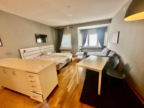 a small room with a bed and a desk and a bedroom at Skarholmen Stockholm Apartment in Stockholm