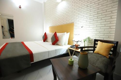a bedroom with a bed and a table and a chair at Hotel The Anvi Residency in Noida