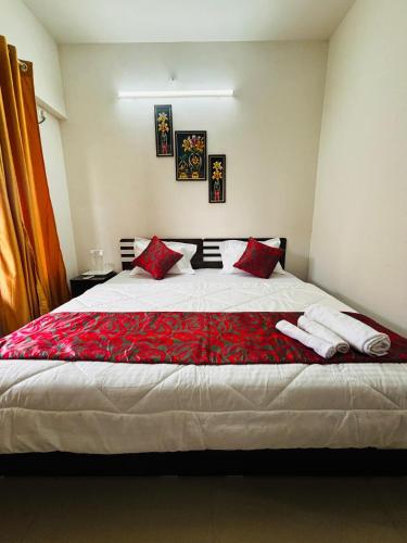Un dormitorio con una cama grande con almohadas rojas. en Private Rooms In Baner, en Pune