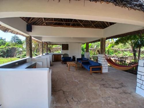 an outdoor patio with couches and a hammock at Sea Soul Sanctuary in Ukunda