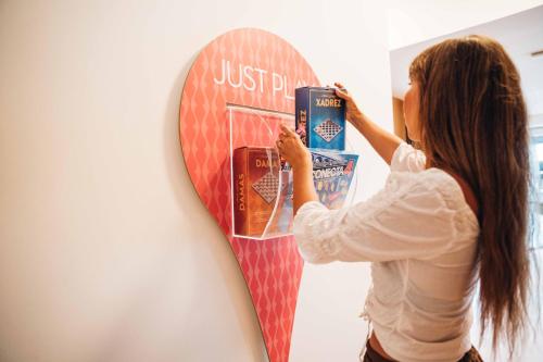 a woman standing next to a surfboard on a wall at Stay Hotel Faro Centro in Faro
