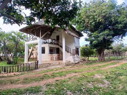 a small white house with a thatched roof at Sea Soul Sanctuary in Ukunda