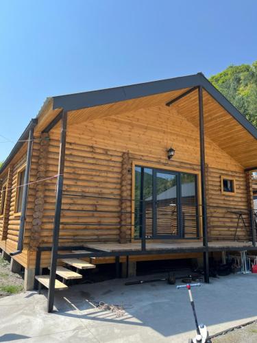 Khando's Resort في Passanauri: كوخ خشبي به نافذة كبيرة في مقدمته