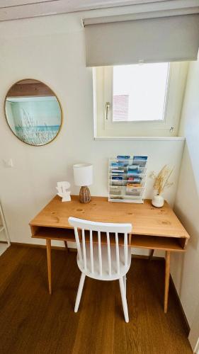 a wooden desk with a white chair and a mirror at SOLUNA STAY I Seesicht I Luzern I Familienfreundlich I Self-check-in I Sunset I Ski I Free Parking in Küssnacht