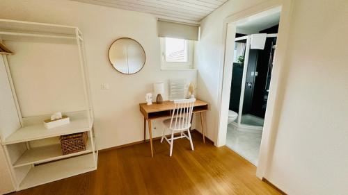 a room with a desk with a mirror and a chair at SOLUNA STAY I Seesicht I Luzern I Familienfreundlich I Self-check-in I Sunset I Ski I Free Parking in Küssnacht