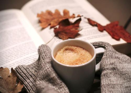 a cup of coffee sitting next to a book at SOLUNA STAY I Seesicht I Luzern I Familienfreundlich I Self-check-in I Sunset I Ski I Free Parking in Küssnacht
