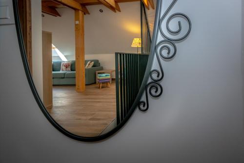 a mirror reflecting a living room with a couch at Apartments Šlosarjeva Hiša Nature & Tradition in Preddvor