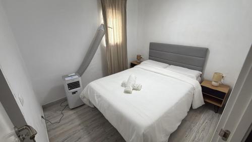 a teddy bear sitting on a bed in a bedroom at SuecaRoom in Sueca