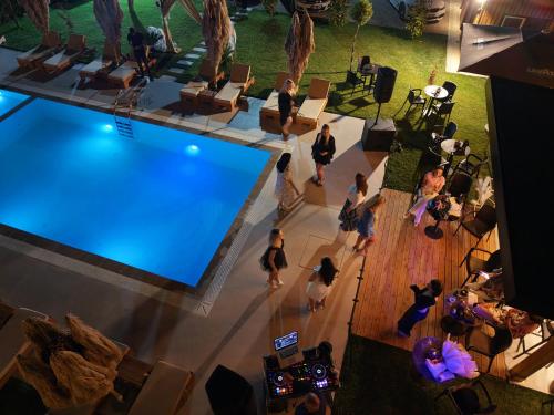 a group of people standing around a swimming pool at Villa Guesthouse Albion in Lezhë