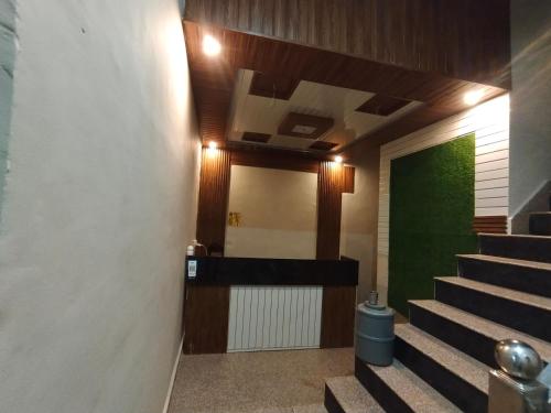 a hallway with stairs and a green wall at TRPOTELS Shree Ji in Gwalior