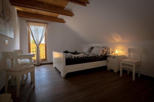 a bedroom with a bed and a table and a window at Apartments Šlosarjeva Hiša Nature & Tradition in Preddvor