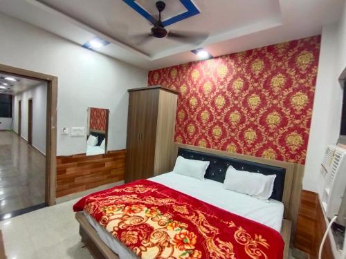 a bedroom with a bed and a red wall at TRPOTELS Shree Ji in Gwalior