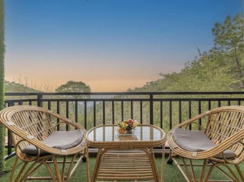 three chairs and a table on a balcony at Evening Sky Homestay - Kasauli !!! in Kasauli