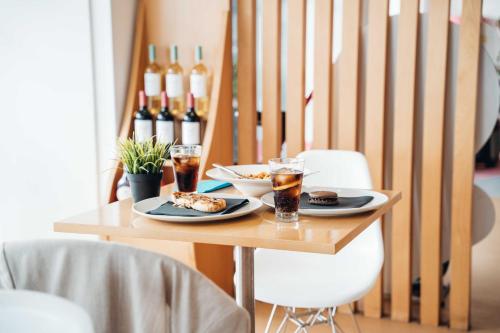 a table with two plates of food and wine bottles at Stay Hotel Faro Centro in Faro