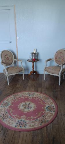 a room with two chairs and a table and a rug at Le domaine du Champ Han in Saint-Hilaire-du-Harcouët