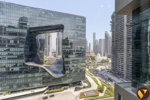 a view of a large glass building in a city at Vogue Vacation Homes, Business Bay Damac Cour Jardin close to Downtown, Burj Khalifa and Dubai Mall, Studio Apartment with City View, Access to all Amenities in Dubai