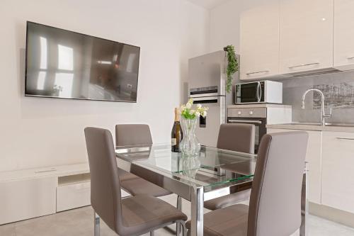 a dining room with a glass table and chairs at Homiday - Grey Apartment - Free Parking in Collesalvetti