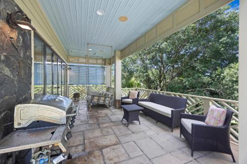 a screened in porch with a couch and chairs at AV9-02: 9 2nd Avenue in Isle of Palms