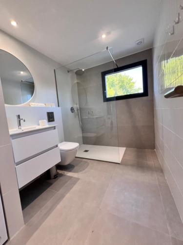 a bathroom with a toilet and a sink and a shower at Camping Joncar Mar in Roses