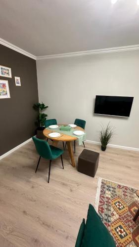 a living room with a table and chairs and a tv at Luna Home in Jermuk