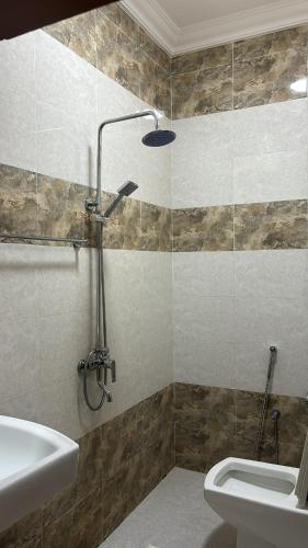 a bathroom with a shower and a toilet and a sink at فندق ثمريت in Thamarīt