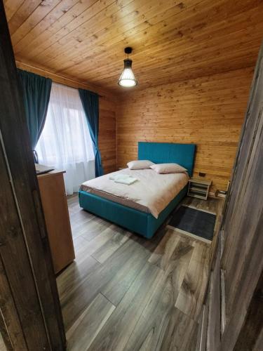 a bedroom with a bed and a wooden ceiling at Cabana Deliuta in Cavnic