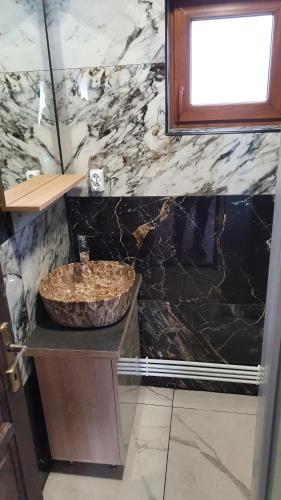 a bathroom with a sink and a marble wall at Cabana Deliuta in Cavnic