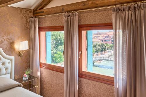 a bedroom with a window with a view of a pool at Hotel Santa Chiara in Venice