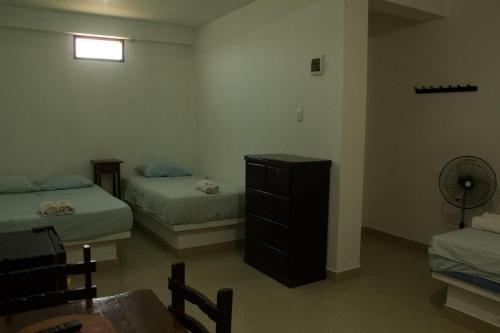 a bedroom with two beds and a dresser in it at Bungalows Rupay Wasi in Los Órganos